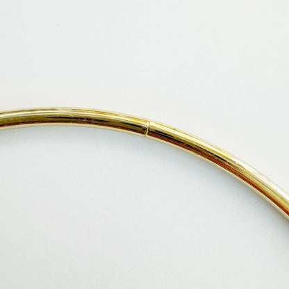 Golden metal ring held in hand, 9.5cm